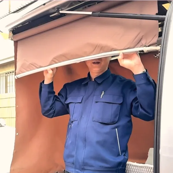周りから見えないよう幕をおろした火葬車